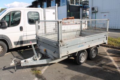 un camion équipé d'une cage à l'arrière, garé sur un parking