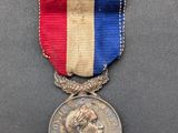 une médaille ornée d'un ruban rouge, blanc et bleu