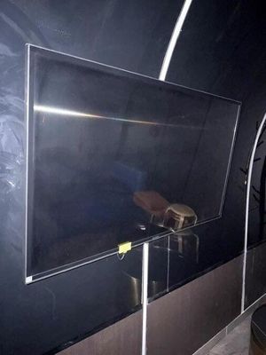une télévision posée sur un meuble dans une pièce dont l'un des murs est noir