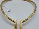 un collier plaqué or avec deux barrettes sur fond blanc