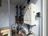 an image of a room with a water heater and pipes on the wall