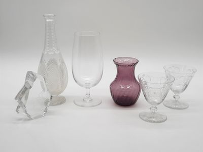 a lot of wine glasses and vases sitting on a table