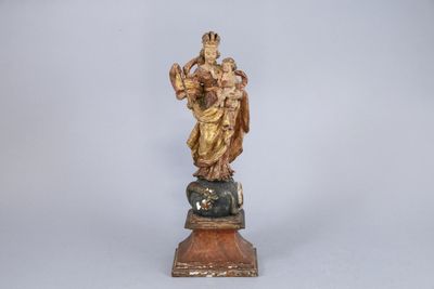 an image of a statue of a woman holding a child on a rock