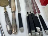 many different types of knives and spoons on a table
