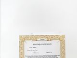 a white paper with a gold border and a certificate on it
