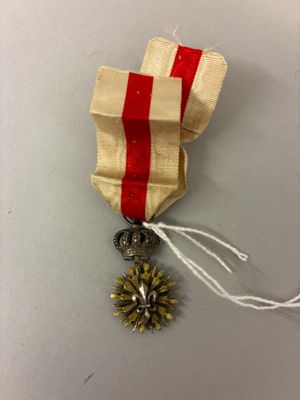 une image représentant une médaille d'or entourée d'un ruban rouge et blanc