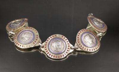 un gros plan d'un bracelet en argent orné d'une pièce de monnaie