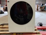 une machine à laver posée sur une palette dans un entrepôt