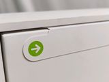 a close up of a white refrigerator with a green arrow on it
