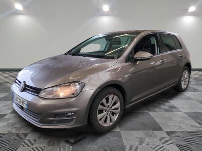 Une Volkswagen Golf grise est garée sur un sol carrelé à damier.
