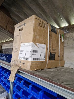 une grande boîte sur un tapis roulant dans un entrepôt