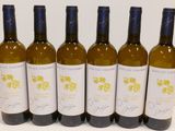six bottles of wine are lined up on a table