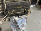 a black and yellow tool bag sitting on top of a blue suitcase