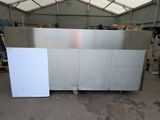 a stainless steel counter in a warehouse with a white board