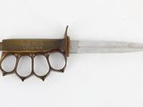 a small knife with a brass handle on a white surface