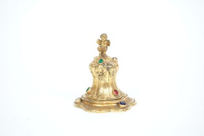 a gold figurine that is sitting on a white surface