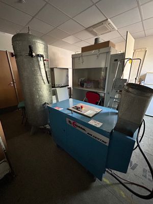 une pièce avec un comptoir bleu et une poubelle en métal