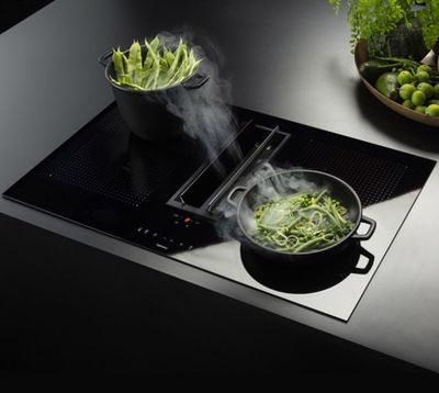 une plaque de cuisson noire sur laquelle est posée une casserole contenant de la nourriture