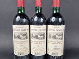 three bottles of red wine sitting next to each other on a table