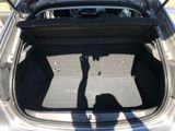 the back of a car with the trunk open and a person holding a cell phone in the trunk
