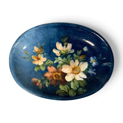 a blue plate with a painting of flowers on it