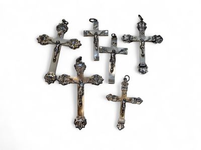 quatre croix métalliques sur une surface blanche, sur fond blanc