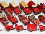 beaucoup de petits camions rouges en plastique sur une surface blanche
