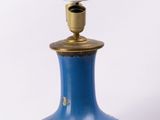 un vase bleu orné de fleurs, posé sur une table