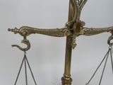 a gold scale with a clock on it on a table