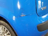 a close up of a blue car parked in a parking lot