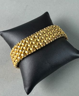 a close up of a gold bracelet on a black pillow