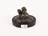 l'image d'une statue de bronze représentant une femme assise sur un rocher