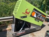 a green machine that is sitting on the side of the road