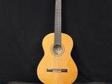 une guitare acoustique posée sur un étui à guitare, sur fond noir