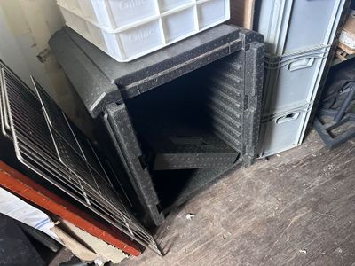 a pile of boxes and crates in the corner of a room