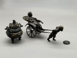 figurine représentant un homme tirant une calèche avec un chien