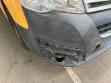 a car that has been dented and is parked in a parking lot