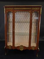 Vitrine sur pieds en bois de placage satiné.