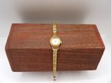 a close up of a wooden box with a watch on it