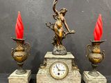 a clock that is sitting on a table next to two vases