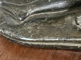 a statue of a woman laying down on a wooden table