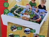 two children playing with a wooden train table