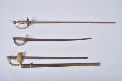 three old swords are displayed in a row on a white surface