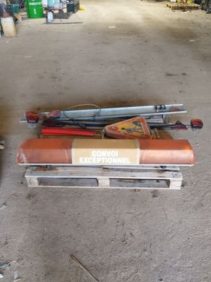 Plusieurs paires de skis sont empilées sur une palette dans un garage
