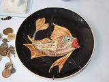 a plate with a fish painted on it on a table