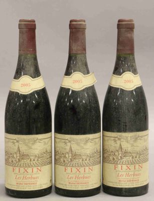 trois bouteilles de vin sont alignées sur une table