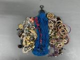 a lot of bracelets and necklaces that are on the table