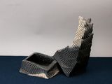 a black and white sculpture of a shoe on a blue surface