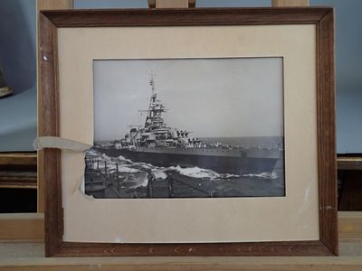 a picture of a ship in a frame on a table