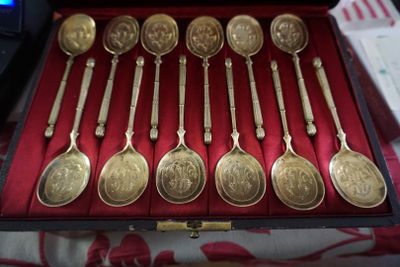 six cuillères dans un étui, posées sur une table